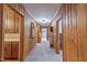 Wood paneled hallway with neutral carpet features vintage design elements and access to multiple rooms throughout the home at 219 E Nash St, Spring Hope, NC 27882