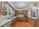 This kitchen features a stainless steel sink, dark wood cabinets, appliances, and a window with natural light at 219 E Nash St, Spring Hope, NC 27882