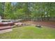 Large backyard features a wood deck, seating, fire pit, lush grass, and mature trees at 2311 Woodwyck Way, Raleigh, NC 27604