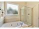 Bathroom with a soaking tub, tiled surround, and separate glass shower at 2311 Woodwyck Way, Raleigh, NC 27604