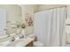 Bright bathroom features a shower-tub combo with white shower curtain and decorative floral accents at 2311 Woodwyck Way, Raleigh, NC 27604