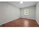 A clean and simple bedroom with a window and hardwood floors at 2324 Hoskins Rd, Burlington, NC 27215