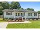 Charming single-story home features white siding, dark shutters, and a well-manicured front yard at 2324 Hoskins Rd, Burlington, NC 27215