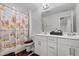 This bathroom features double sinks, white cabinets and beach-themed shower curtain at 2346 Mckenzie Ridge Ln, Apex, NC 27502