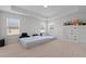 Bright bedroom featuring three windows, neutral carpeting, and tray ceiling at 2346 Mckenzie Ridge Ln, Apex, NC 27502