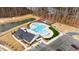 Aerial view showcasing a community pool, pond, and playground nestled near a wooded area at 2346 Mckenzie Ridge Ln, Apex, NC 27502