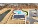 Aerial view of community pool, pond, and adjacent parking with wooded backdrop in a planned community at 2346 Mckenzie Ridge Ln, Apex, NC 27502