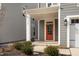 Inviting front porch featuring an orange door and a covered entrance for guests and homeowners alike at 2346 Mckenzie Ridge Ln, Apex, NC 27502
