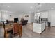 Open-concept living area with modern island kitchen, wood dining table, and comfortable seating area at 2346 Mckenzie Ridge Ln, Apex, NC 27502