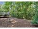 Spacious backyard featuring a wooden deck, surrounded by mature trees and natural landscaping at 2425 Lemuel Dr, Raleigh, NC 27615