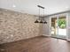 Industrial style dining area with a brick accent wall, industrial light fixtures, and views to the backyard at 2508 Kearney Rd, Wake Forest, NC 27587