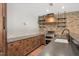 This kitchen showcases a brick wall, floating shelves, stainless appliances, and wood cabinetry at 2508 Kearney Rd, Wake Forest, NC 27587