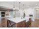 Open concept kitchen with a large island, stainless sink, marble counters and view to living room at 2508 Kearney Rd, Wake Forest, NC 27587