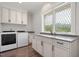 Well-lit laundry room features granite countertops, white cabinets, washer, and dryer with a decorative window at 2508 Kearney Rd, Wake Forest, NC 27587