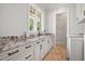 Well-lit laundry room with granite countertops, white cabinets and brick floors at 2508 Kearney Rd, Wake Forest, NC 27587
