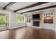 Inviting living room with exposed beams, brick fireplace, built-in cabinets, and access to the porch at 2508 Kearney Rd, Wake Forest, NC 27587