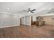 Open concept living room with wood-look tile flooring, brick accents, a ceiling fan, and views to an island bar at 2508 Kearney Rd, Wake Forest, NC 27587