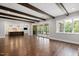 Open living space featuring hardwood floors, exposed beams, access to porch, and a glimpse of the kitchen at 2508 Kearney Rd, Wake Forest, NC 27587