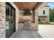 A covered outdoor kitchen featuring stainless steel appliances and brick accents at 2508 Kearney Rd, Wake Forest, NC 27587