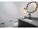 A powder room with a unique antler mirror and a dark vanity with stone counter tops at 2508 Kearney Rd, Wake Forest, NC 27587