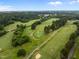 A picturesque aerial view captures the sprawling golf course with lush green fairways, mature trees, and bunkers at 2551 Drake Ave, Durham, NC 27705