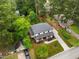 This aerial view shows mature trees, lush landscaping, a paved driveway and a covered front porch at 2551 Drake Ave, Durham, NC 27705