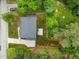 An aerial view shows a home with a paved driveway, fenced-in backyard, mature trees and landscaping at 2551 Drake Ave, Durham, NC 27705