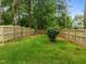 Expansive, fenced backyard featuring a manicured lawn with mature trees providing lots of shade at 2551 Drake Ave, Durham, NC 27705