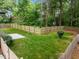 Spacious backyard featuring a well-maintained lawn, wooden fence, and mature trees providing shade at 2551 Drake Ave, Durham, NC 27705