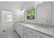 Bathroom with marble counters, double sinks, vanity and a window with a view at 2551 Drake Ave, Durham, NC 27705
