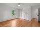 Empty bedroom with hardwood floors, a built-in shelving unit, closet, and a large window at 2551 Drake Ave, Durham, NC 27705