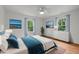 Bright bedroom with white walls, beach themed wall art, a ceiling fan, and plush bedding at 2551 Drake Ave, Durham, NC 27705