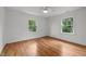 Empty bedroom features hardwood floors, white trim, and two windows at 2551 Drake Ave, Durham, NC 27705