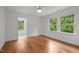 Sun-filled bedroom featuring gleaming hardwood floors, a ceiling fan, and a picturesque view from the windows at 2551 Drake Ave, Durham, NC 27705