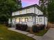 Charming two-story home featuring a welcoming front porch, manicured lawn, and beautiful landscaping at 2551 Drake Ave, Durham, NC 27705