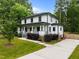 Two-story home has white siding, covered porch, and long driveway at 2551 Drake Ave, Durham, NC 27705
