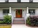 Inviting front entrance with a wood door and porch featuring decorative columns and well-maintained landscaping at 2551 Drake Ave, Durham, NC 27705
