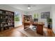 Inviting home office with dark wood desk, bookshelves, hardwood floors, and natural light from surrounding windows at 2551 Drake Ave, Durham, NC 27705