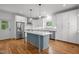Bright kitchen featuring white cabinets, stainless steel appliances, hardwood floors, and a blue kitchen island at 2551 Drake Ave, Durham, NC 27705