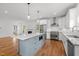 Bright kitchen featuring white cabinets, stainless steel appliances, hardwood floors, and a blue kitchen island at 2551 Drake Ave, Durham, NC 27705