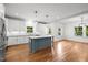 Bright kitchen featuring white cabinets, stainless steel appliances, hardwood floors, and a blue kitchen island at 2551 Drake Ave, Durham, NC 27705