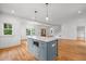 Bright kitchen featuring white cabinets, stainless steel appliances, hardwood floors, and a blue kitchen island at 2551 Drake Ave, Durham, NC 27705