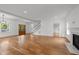Open concept living room with a fireplace, hardwood floors, and staircase with lots of natural light at 2551 Drake Ave, Durham, NC 27705