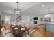 Open living area with a dining table, adjacent to a modern kitchen and a cozy fireplace at 2551 Drake Ave, Durham, NC 27705