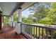 Covered porch with wood floors and white railings overlooks lush landscaping at 2551 Drake Ave, Durham, NC 27705
