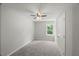 Neutral bedroom with ceiling fan, plush carpet, and a bright window view at 2617 Fayetteville St, Durham, NC 27707