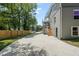 Long driveway leading to a gray two-story home with a backyard fence and a stairway to a screened-in porch at 2617 Fayetteville St, Durham, NC 27707