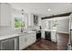 Bright kitchen featuring white cabinets, stainless steel appliances, hardwood flooring, and a wine cooler at 2617 Fayetteville St, Durham, NC 27707