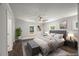 Staged main bedroom featuring a ceiling fan, stylish decor, and refinished hardwood floors at 2617 Fayetteville St, Durham, NC 27707