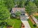 Aerial view of home with a lush lawn, mature trees, and long driveway at 3034 Lewis Farm Rd, Raleigh, NC 27607